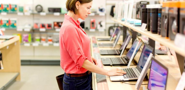 Woman in store trying out laptops