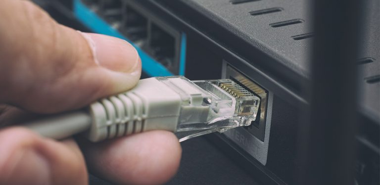 Person plugging in cable to a router