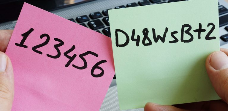 Passwords written on sticky notes with laptop in background