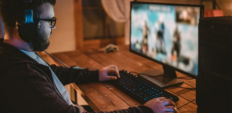 Man playing video game on his desktop computer