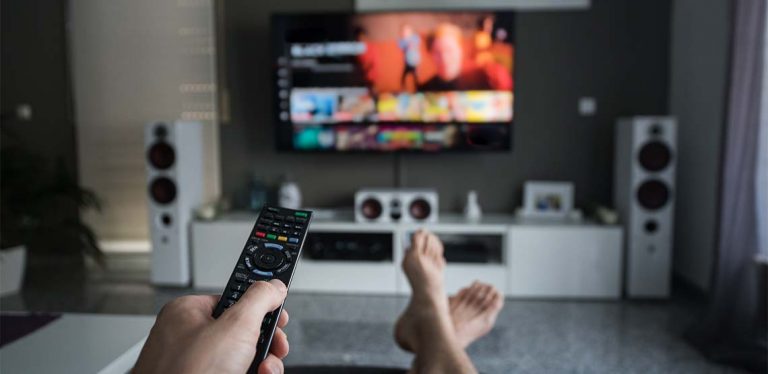 Someone pointing a remote at a TV to watch Netflix.